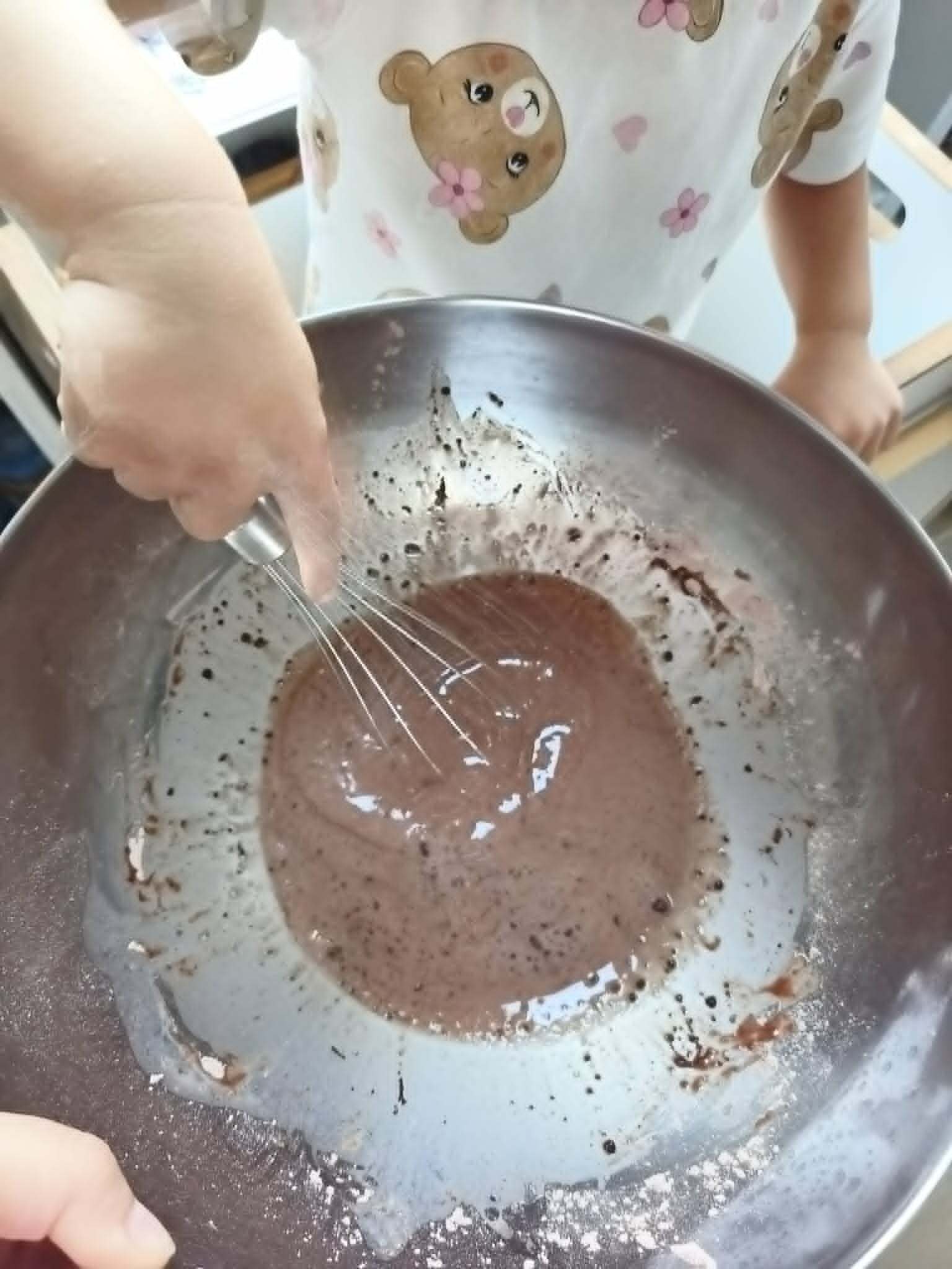 Nauka mówienia podczas gotowania — córka miesza ciasto na omlet trzepaczką